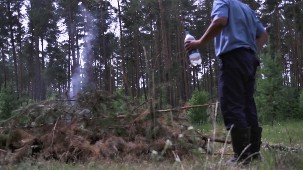 숲 에서 캠프 불 을 지켜보고 있는 사람