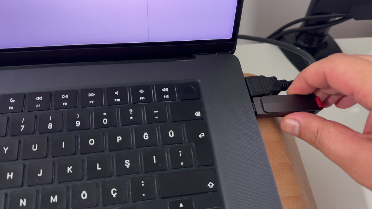 Hand unplugging flash drive into USB port in laptop