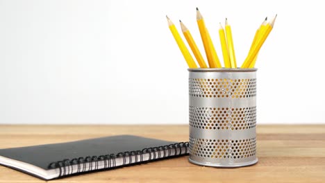 close-up of pen holder with pencil and diary