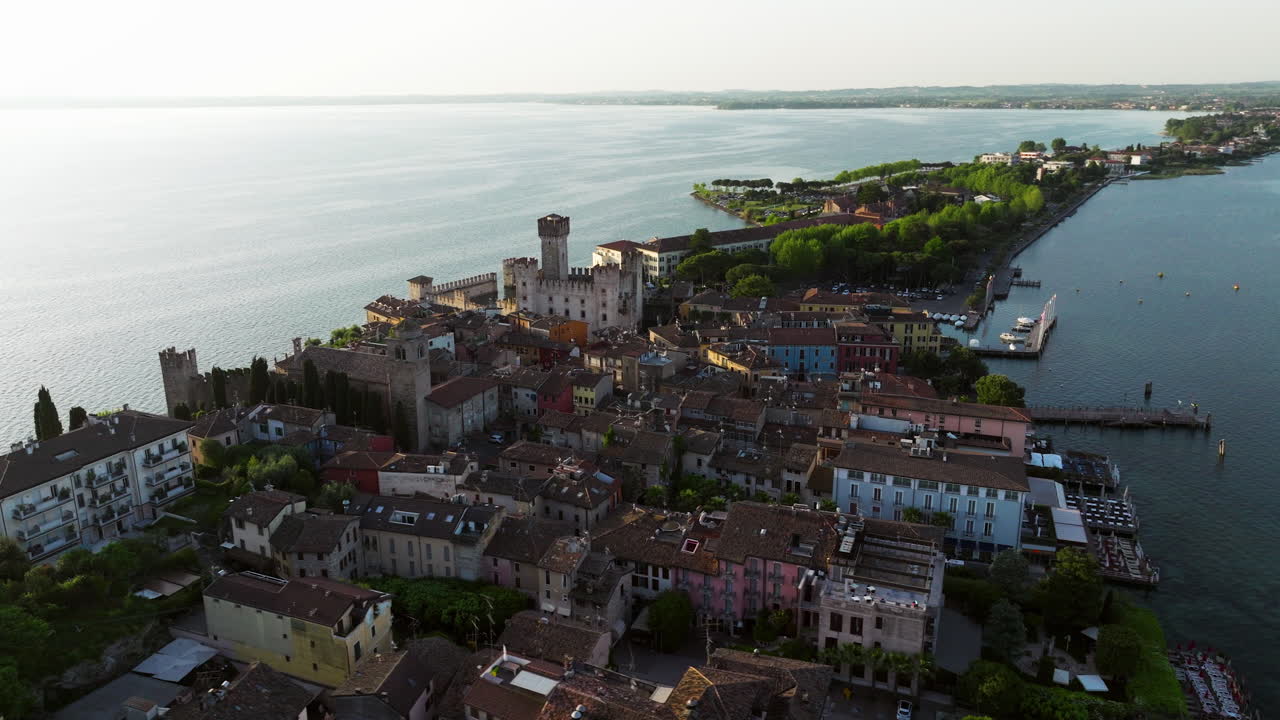 Sirmione, Italy In The Morning - Historic Town On Lake Garda With Scaligero Castle In View. aerial orbiting shot