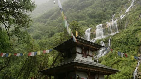 buddhist temple in nature and mountains, temple in the mountains of nepal with waterfall and lush green scenery, religious building in beautiful landscape and nature