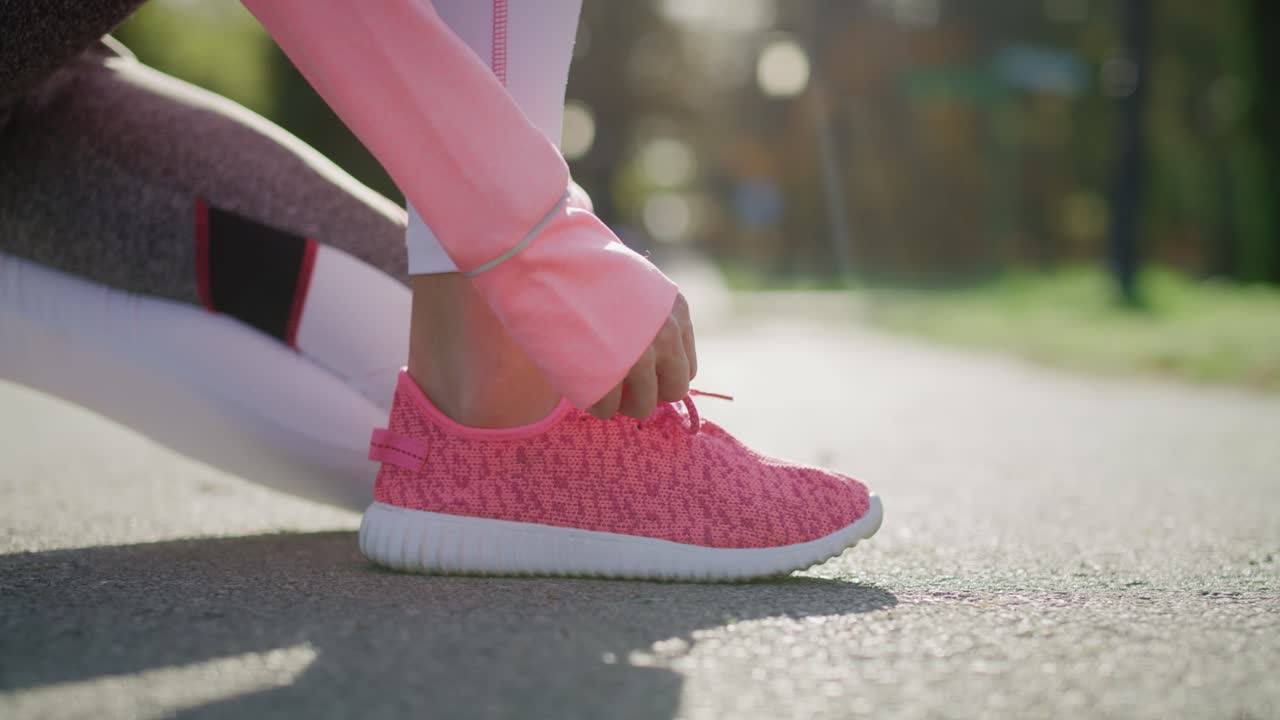 Handheld view of woman&rsquo;s hands tying her sports shoes