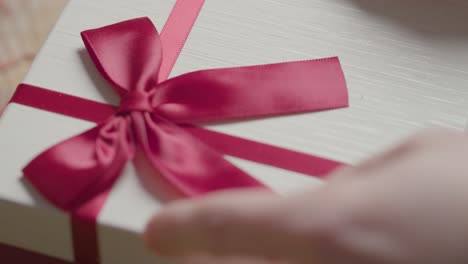 primer plano de hombre regalo envolviendo romántico regalo de san valentín de perfume en caja en la mesa 2