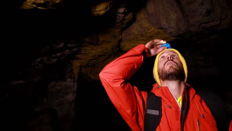 male hiker exploring a dark cave 4k