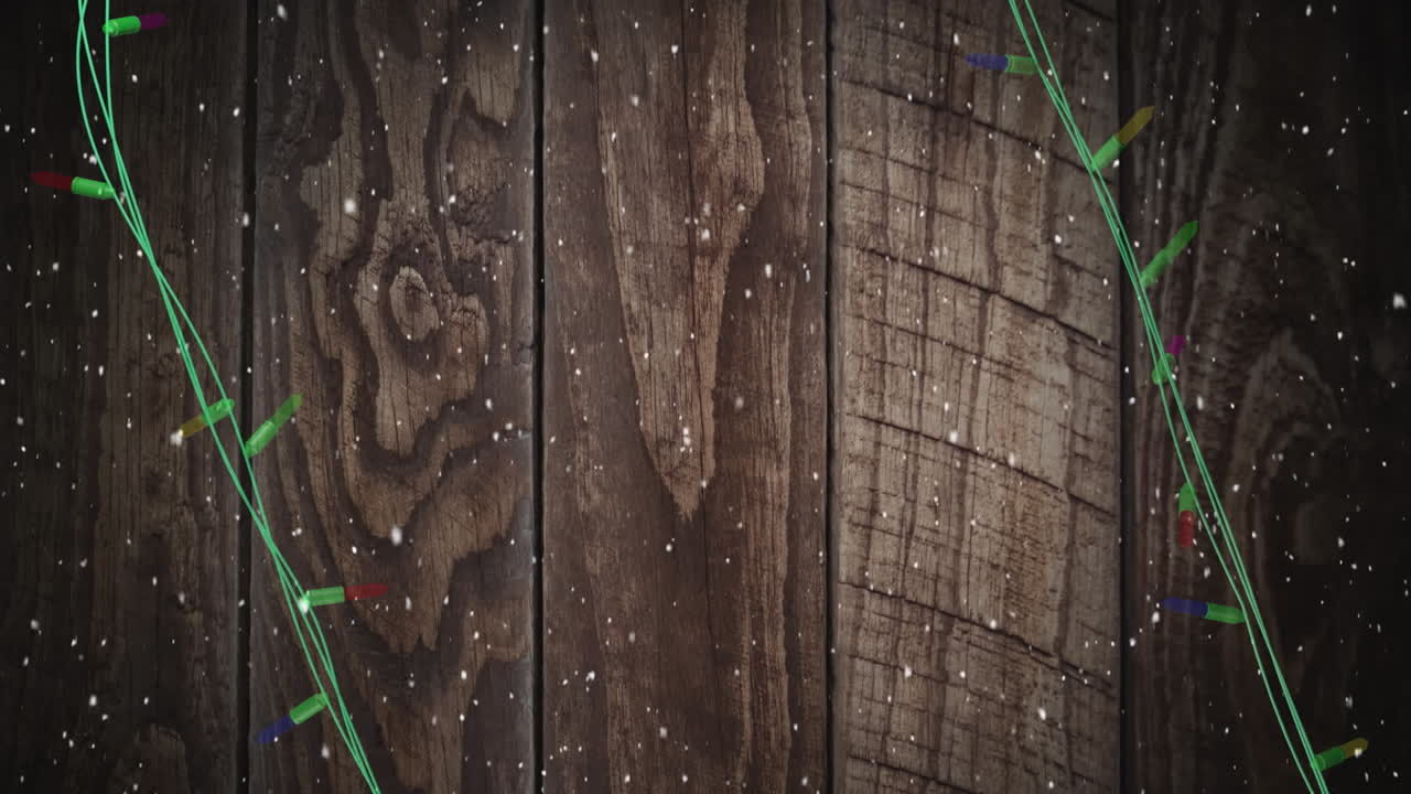 Coloured christmas string lights flashing over wooden boards background, copy space