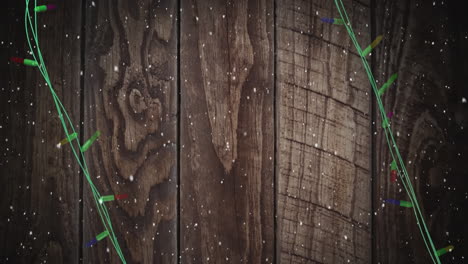 coloured christmas string lights flashing over wooden boards background, copy space