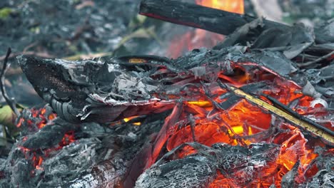 close shot of a small fire burning and smouldering with orange flames