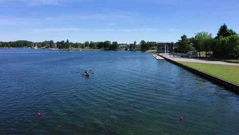 AERIAL:-Tired-Athletes-in-Canoe-Sails-Towards-the-Shore-Across-Buoy-Marked-Lines