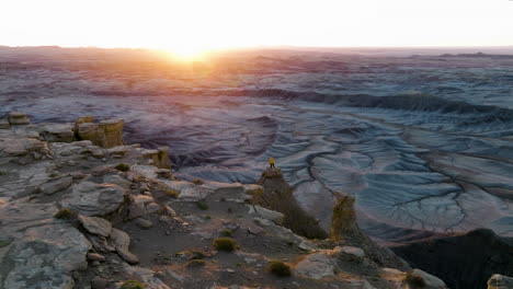 Drohne-Umkreist-Eine-Person-An-Der-Spitze-Steiler-Schluchten-Während-Des-Sonnenaufgangs-In-Utah,-Usa