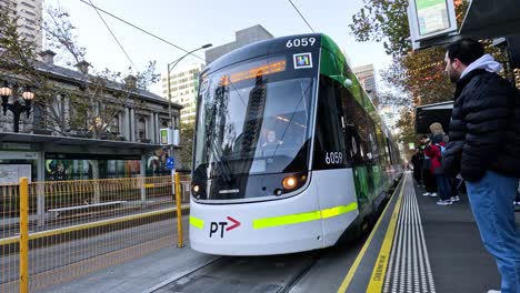 gente esperando el tranvía en la parada de melbourne.