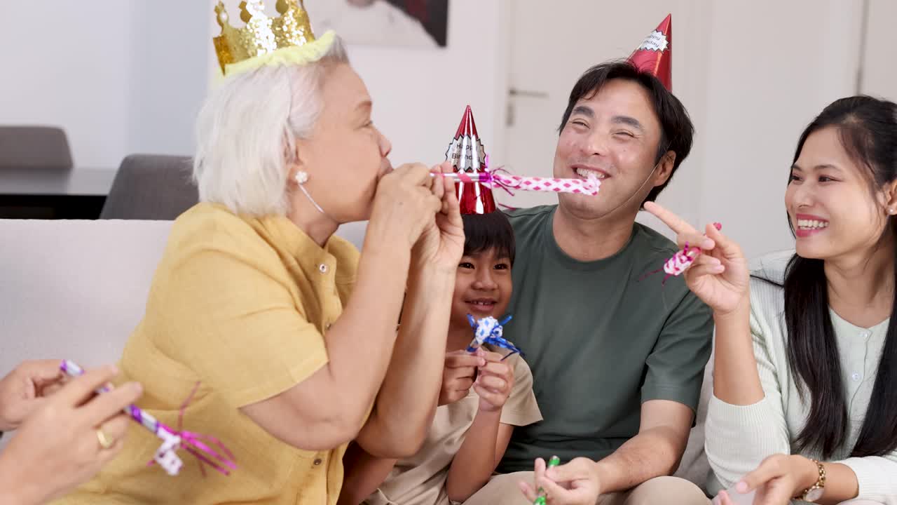 Elderly family member enjoys a lively birthday party with loved ones, featuring laughter, party hats, and festive decorations