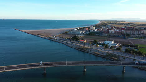 Trucks-crossing-a-bridge-commercial-area-Valencia-Pinedo-beach-aerial-shot-Spain