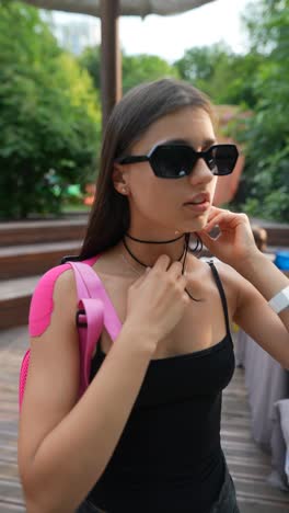 woman adjusting necklace in a park