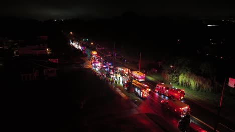 large number of police, fire department and ambulance cars on street at night. car accident on wet road after rain, aerial establishing shot.
