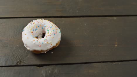 Video-of-donut-with-icing-on-wooden-background