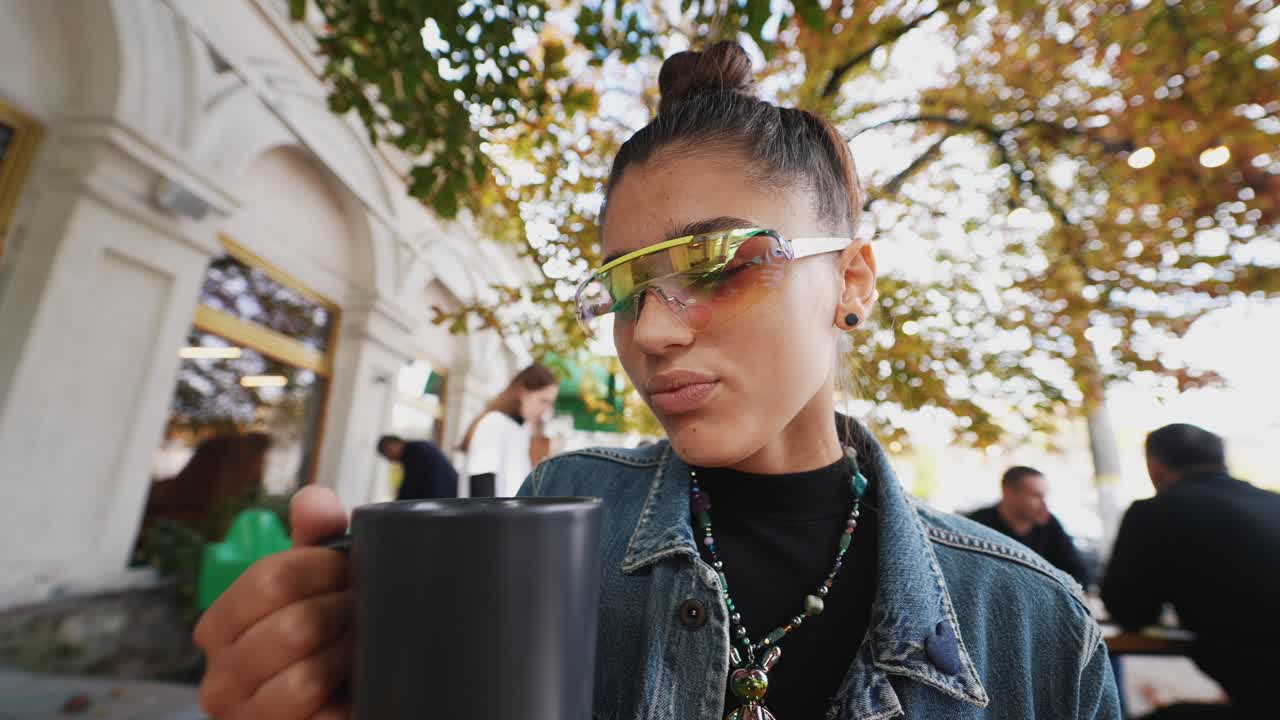 mujer joven bebiendo café al aire libre