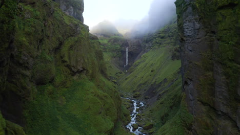 Drone-flying-through-deep-Icelandic-Mulagljufur-canyon,-with-dramatic-Hangandifoss-waterfall-at-the-end-of-the-canyon,-in-Southern-Region,-Iceland