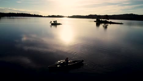 beautiful colorado sunrise on a lake with a silhouette of a canoe against the rising sun