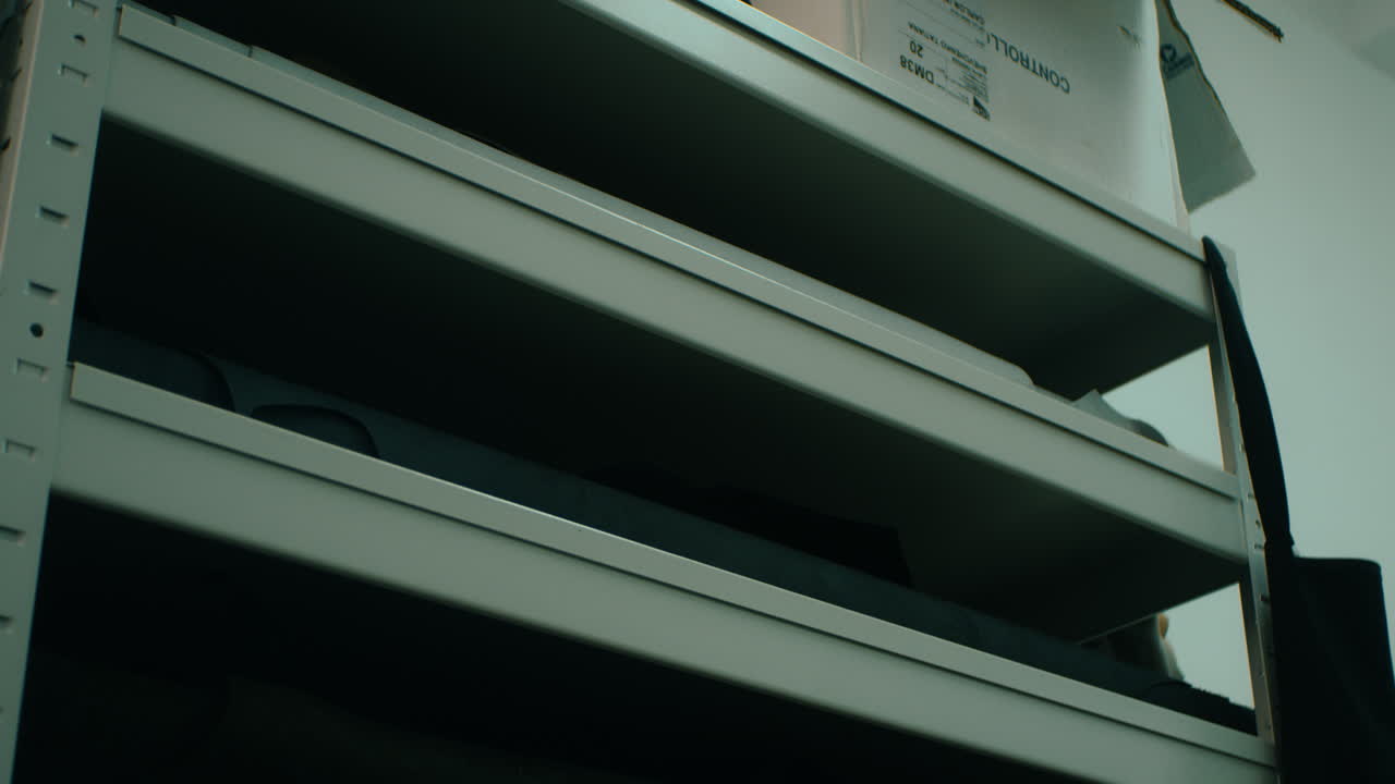 artesano tomando un rollo de cuero del estante. artesano trabajando en el taller