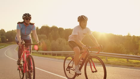 a man and a woman ride sports bikes on the highway at sunset in gear and protective helmets in slow motion 120 fps.