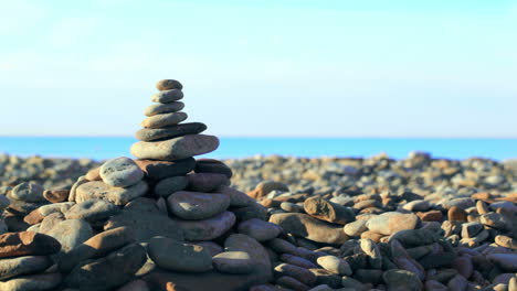 Mano-Poniendo-La-última-Piedra-De-La-Pirámide-A-La-Orilla-Del-Mar.