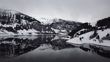 increíble hermoso vuelo de cámara sobre un lago de montaña reflectante en el invierno en suiza
