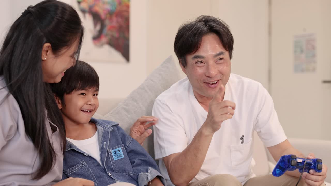 A family enjoys playing video games together, sharing laughter and joy in a cozy living room setting