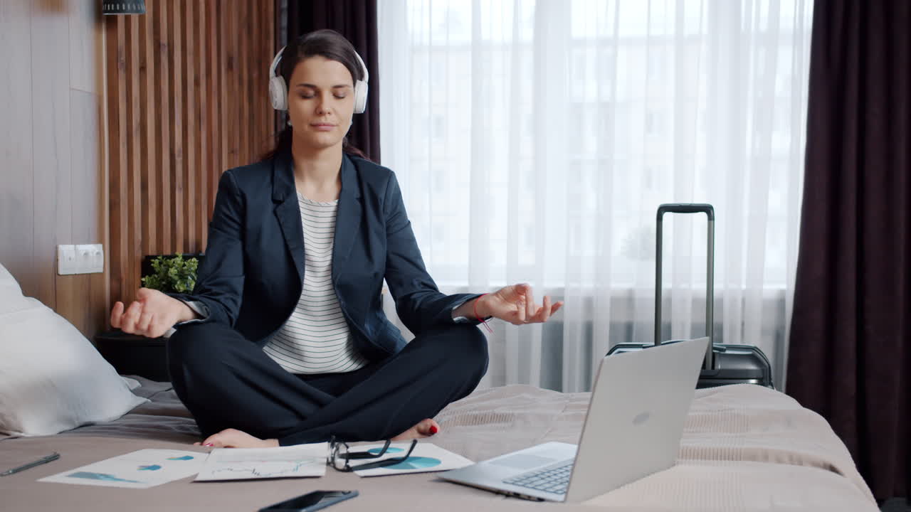 Businesswoman Meditating in Hotel Room While Working from Home