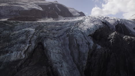 Aerial-view-of-Pasterze-Glacier-lagoon-covered-in-moraine-in-the-lower-part-of-Grossglockner-Mountain,-Austria