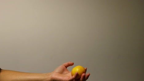 a hand throws and catches an orange