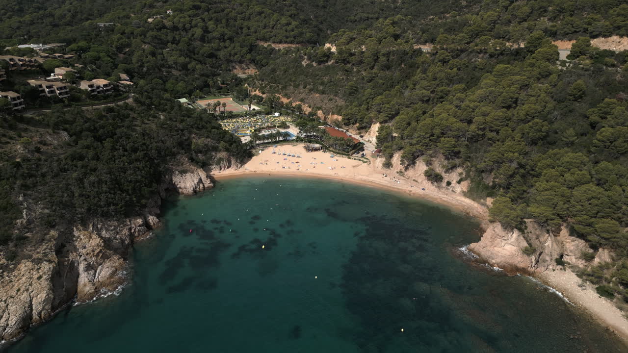 Ampia ripresa con drone che scende su una spiaggia spagnola a Giverola, Costa Brava