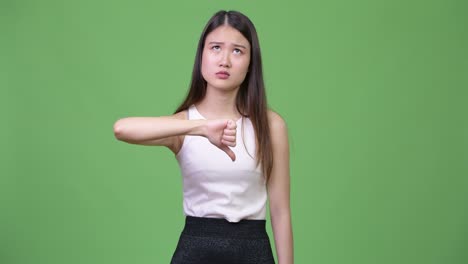 young beautiful asian businesswoman giving thumbs down