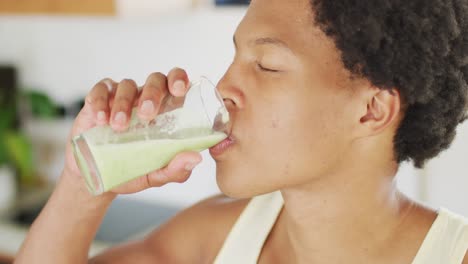 Hombre-Afroamericano-En-Forma-Cocinando,-Bebiendo-Batido-Verde-Saludable