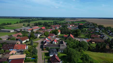 idyllic scenery of tarmow, a small village nestled amidst vast agricultural fields in brandenburg, germany, on a sunny summer day. fly reverse drone