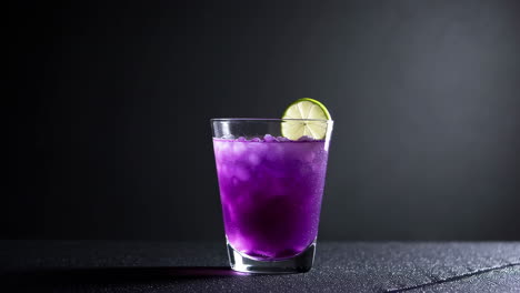 purple cocktail with lime