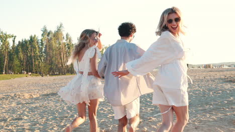 friends running on the beach at sunset