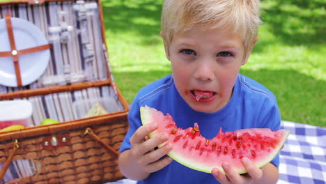 boy eating a watermelon and smiling