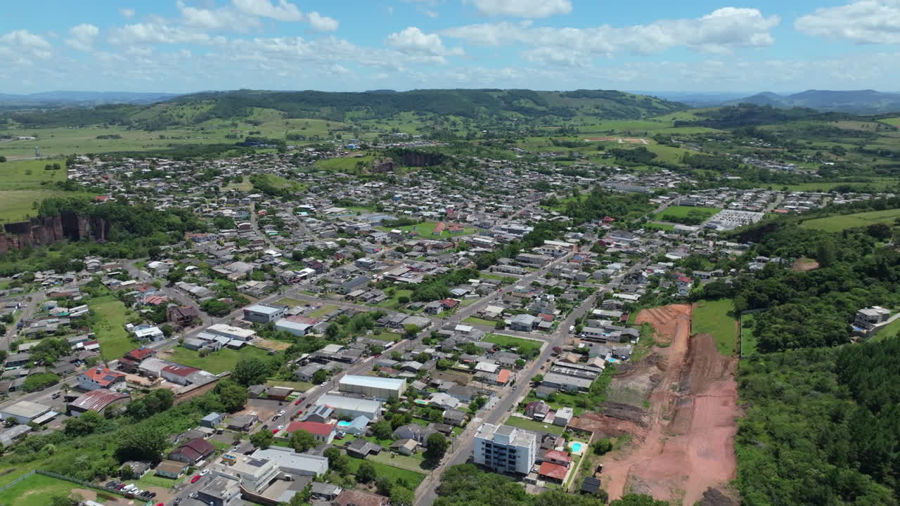 Rekaman drone yang ditarik mundur di atas kawasan perumahan di Santo Antonio da Patrulha, Rio Grande do Sul, Brasil, dengan bekas lokasi tambang. Direkam dalam D Log dengan warna 10-bit.