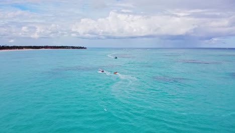 gente divirtiéndose en botes y tubos en la cálida playa de arena en la república dominicana en un día nublado