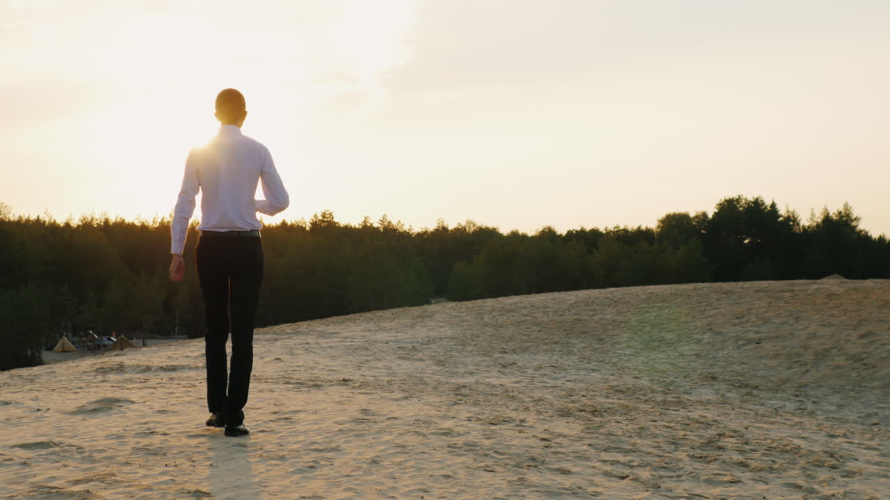 бизнесмен с бутылкой алкоголя идет вперед по песку 3