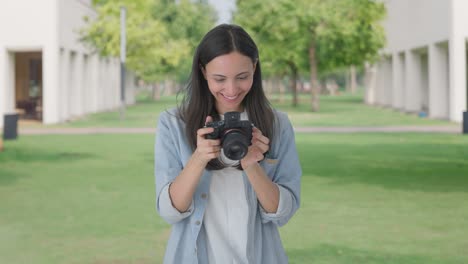 happy indian girl clicking photos using a camera