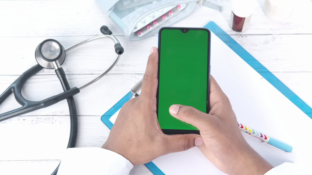 vista superior médico masculino usando un teléfono inteligente en el escritorio de la clínica