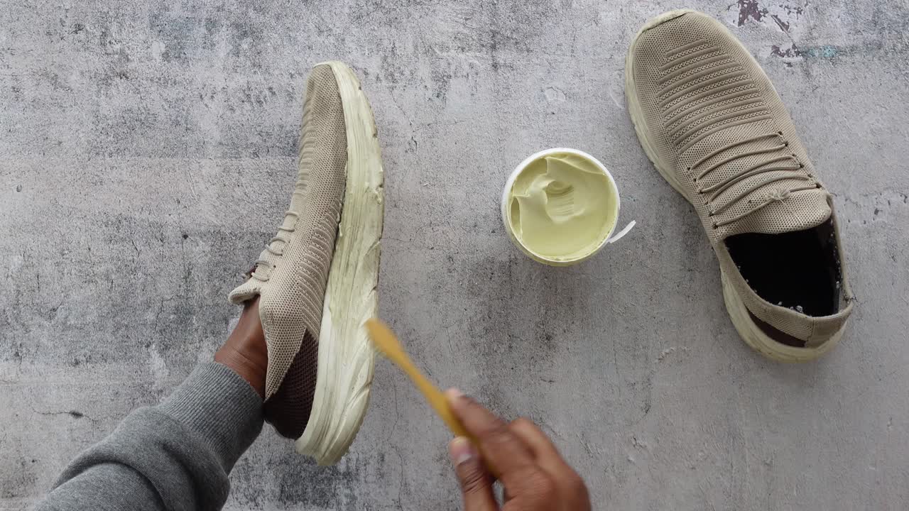 una persona limpiando un par de zapatillas de deporte