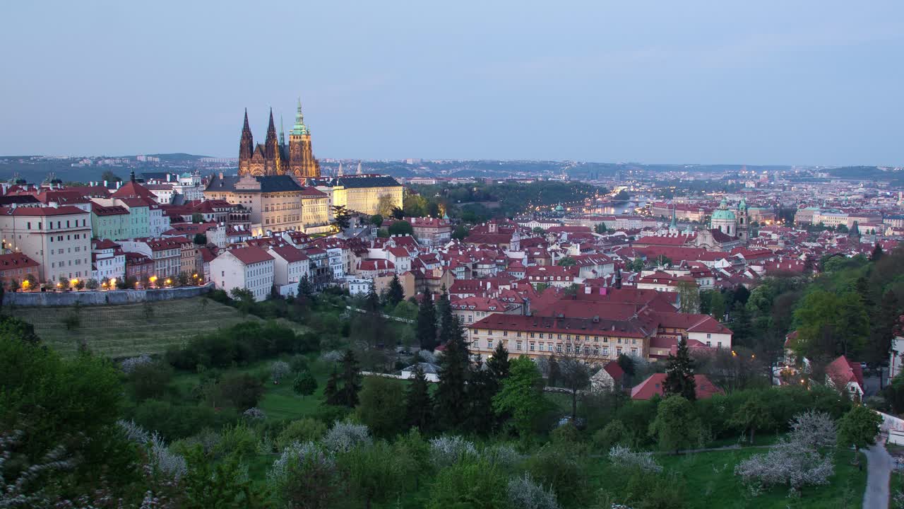 Day to night timelapse in Prague, Czech Republic as seen from Strahov gardens with view of Prague Castle lighting up, Malá strana and downtown in the distance