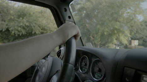 closeup of steering wheel in jeep as boy is driving on a pretty day