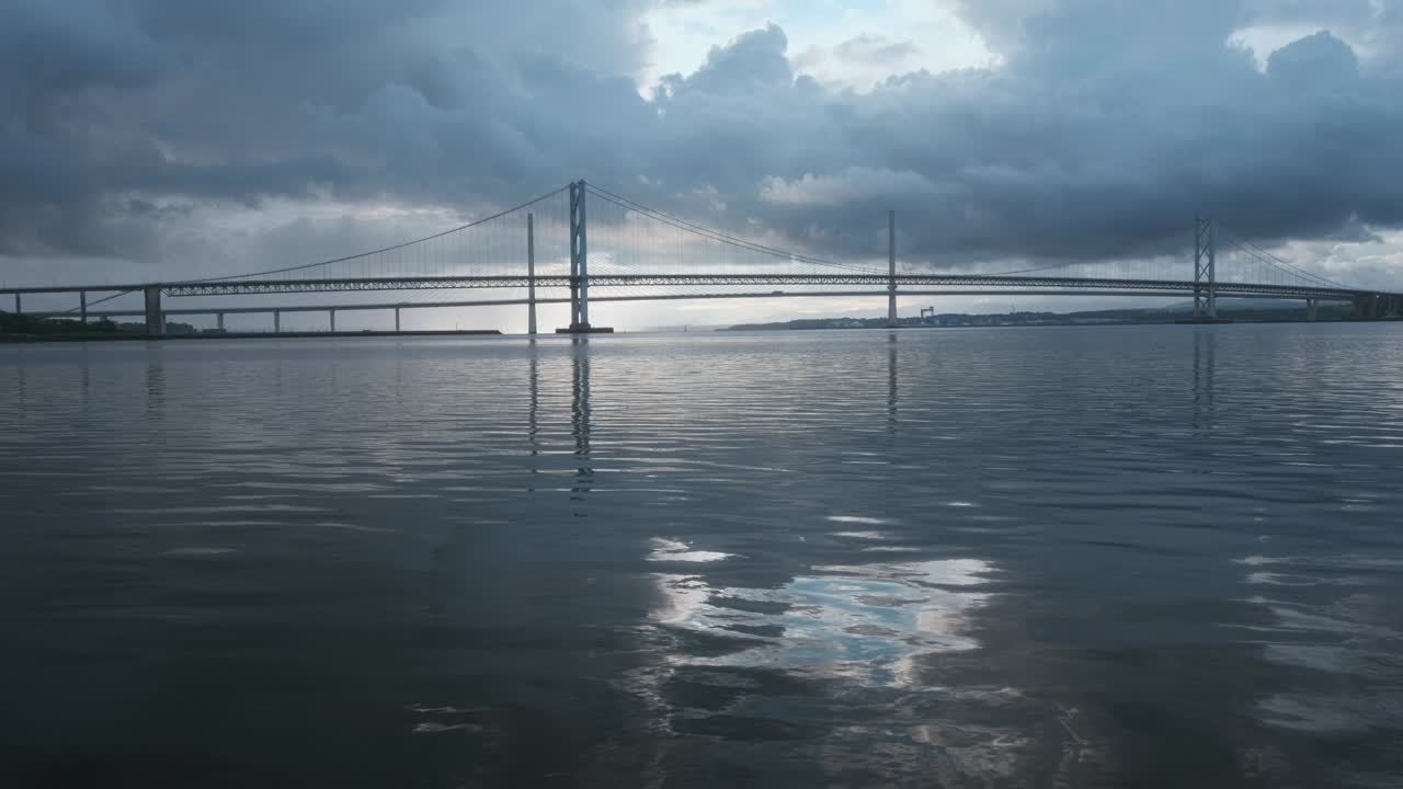 큰 세 탑의 케이블 다리와 물 속의 하늘의 반사.
