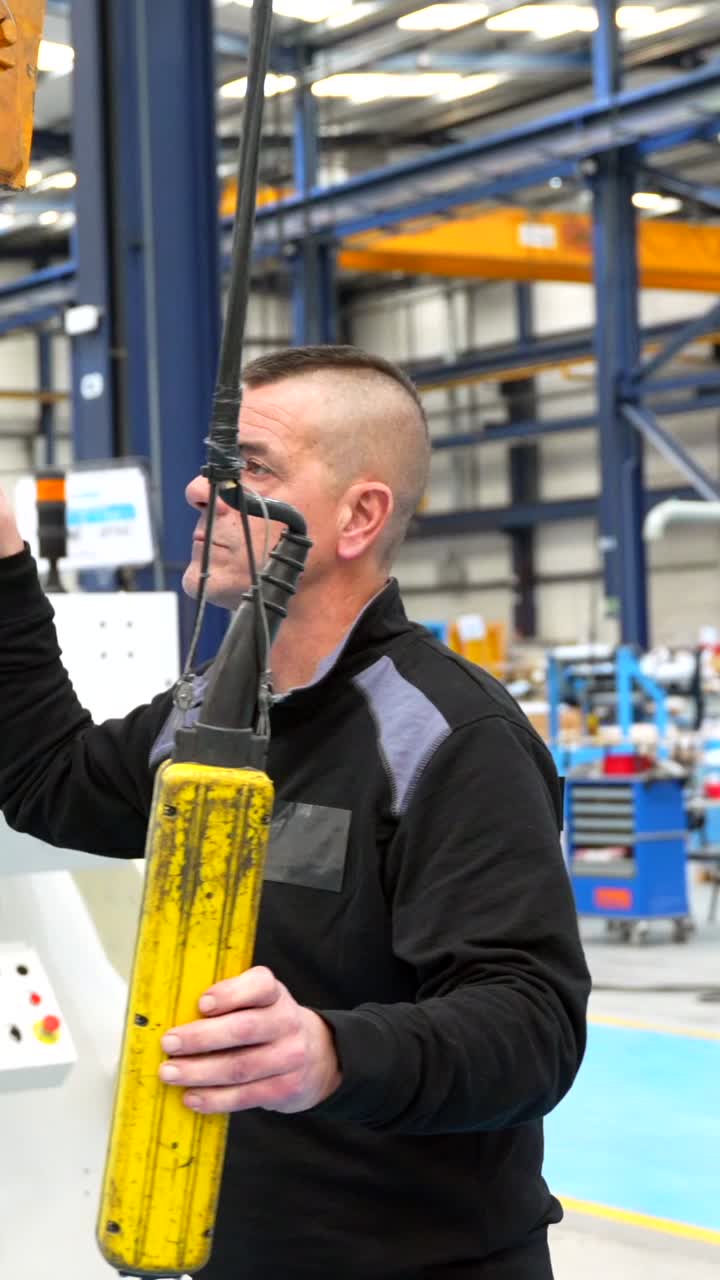 Man Operating Crane in Factory