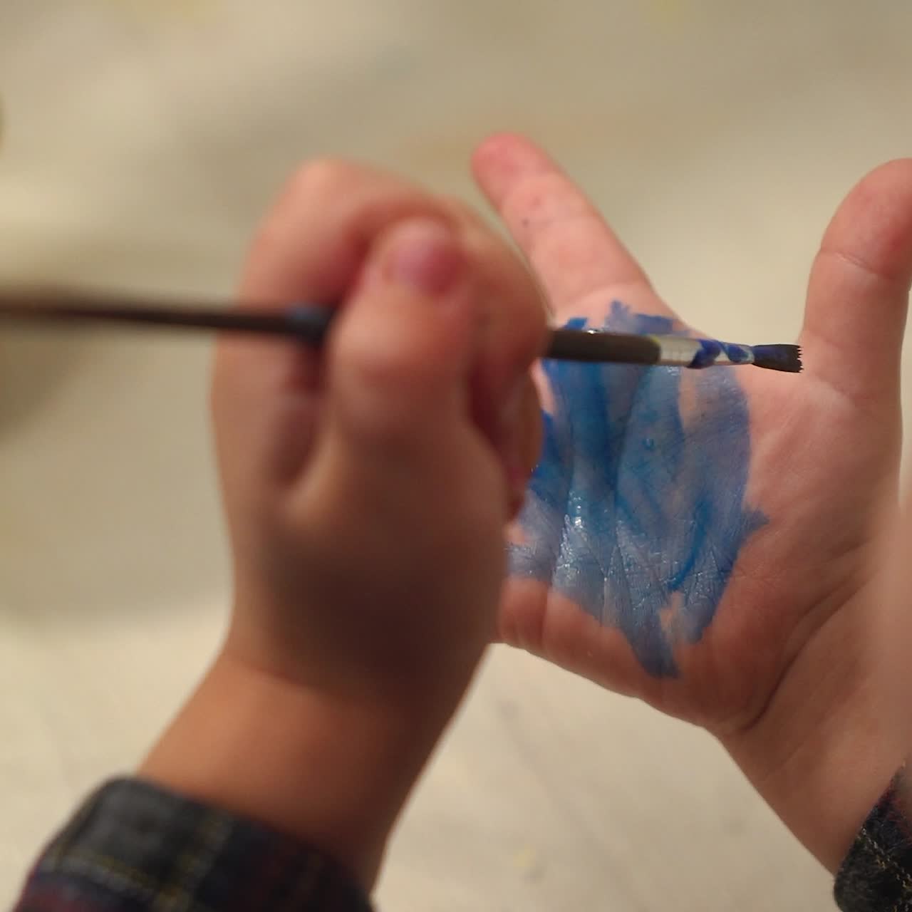 Funny child paints his hands with paint. Baby artist.
