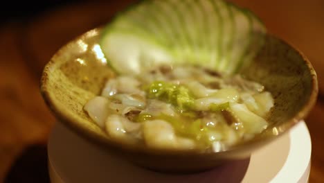 close-up of japanese dish with sliced cucumber