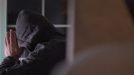 man with a black hood over his head praying